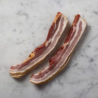 slices of raw nitrate free streaky bacon on a marble surface