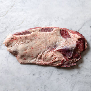 Uncooked flat brisket on a marble surface