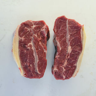 2 feather blade steaks on white marble