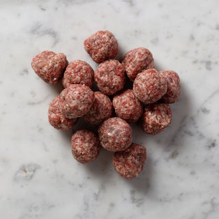 uncooked meat balls on a marble slab