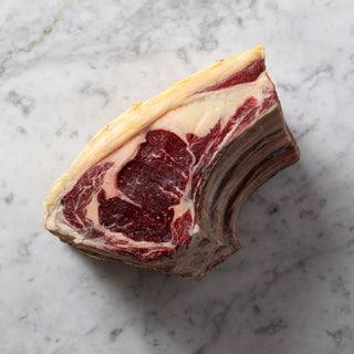 Marbled raw beef ribeye on a marble surface