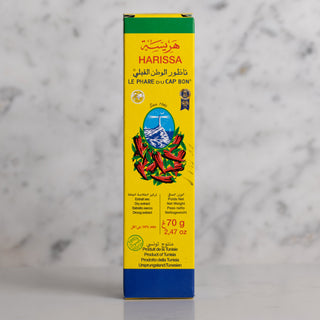 Harissa spice box with yellow and blue design on a gray background